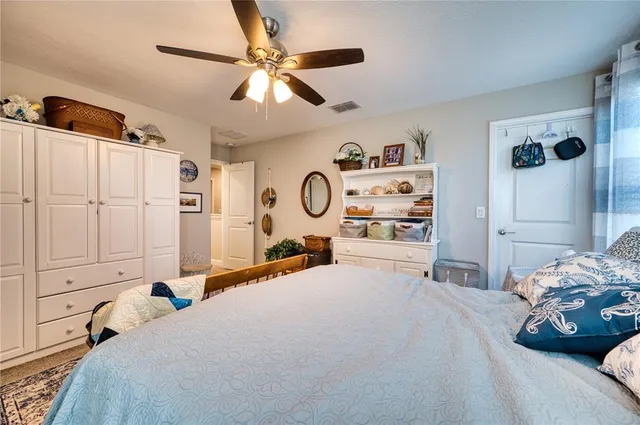 a bedroom with a bed and a large mirror with the dresser