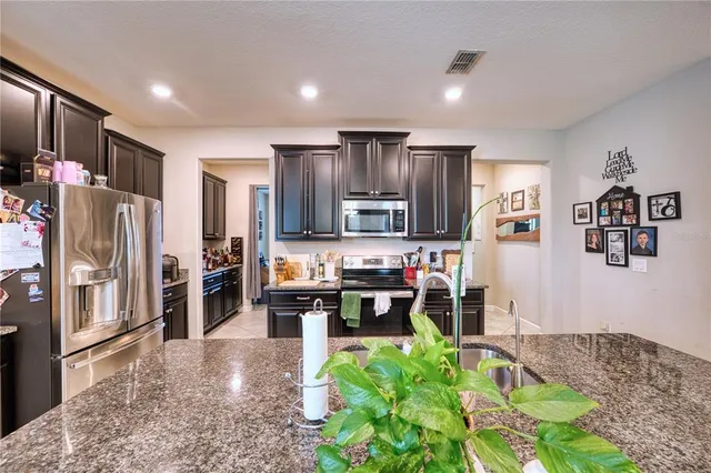 a kitchen with stainless steel appliances granite countertop a refrigerator and a stove