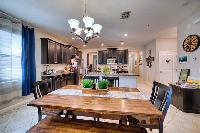 a view of a dining room with furniture a chandelier and wooden floor