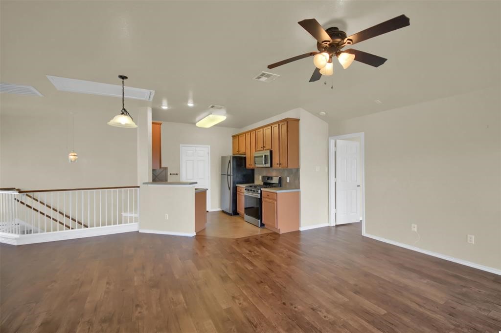 1900 Scofield Ridge Parkway, Unit 3401 Austin, TX 78727 - Photo 12 of 37 a view of a kitchen with a refrigerator a sink a ceiling fan and wooden floor