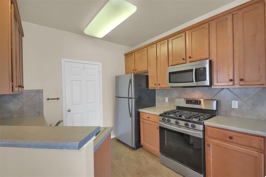 1900 Scofield Ridge Parkway, Unit 3401 Austin, TX 78727 - Photo 18 of 37 a kitchen with granite countertop a stove and a refrigerator