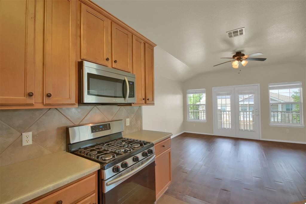 1900 Scofield Ridge Parkway, Unit 3401 Austin, TX 78727 - Photo 20 of 37 a kitchen with granite countertop a stove and a wooden floor