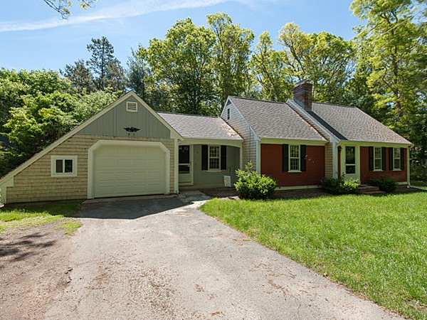 a front view of a house with a yard and trees