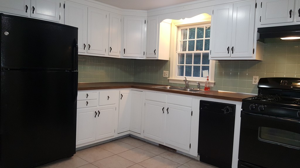 95 Holly Hill Road Barnstable, MA 02632 - Photo 8 of 16 a kitchen with granite countertop white cabinets and black appliances
