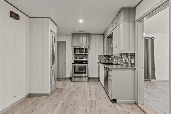 a kitchen with stainless steel appliances a refrigerator and a stove top oven
