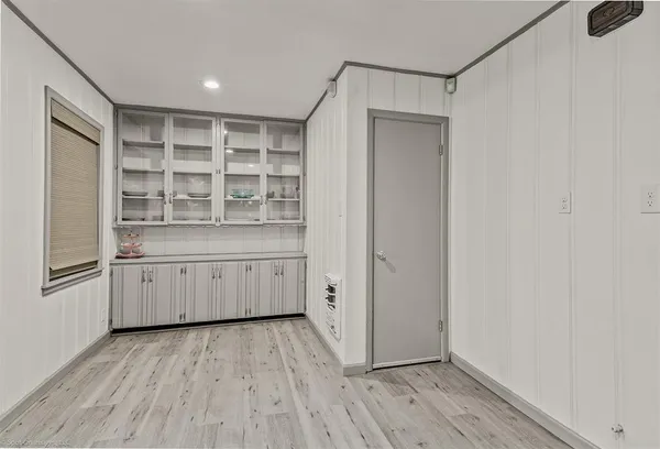 a kitchen with a wooden floor and white cabinets