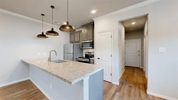 a kitchen with a sink a counter space and wooden floor