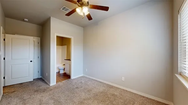 an empty room with closet and a chandelier fan