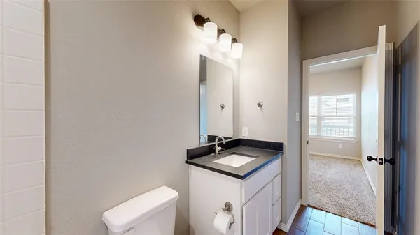 a kitchen with a sink and a stove with wooden floor