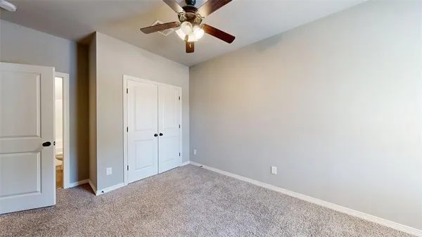 an empty room with closet and a chandelier fan