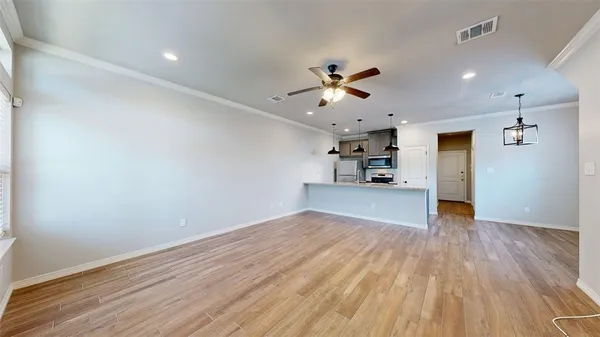 a view of empty room with wooden floor and ceiling fan