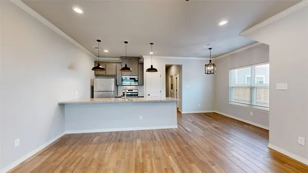 a view of a kitchen with wooden floor and a sink