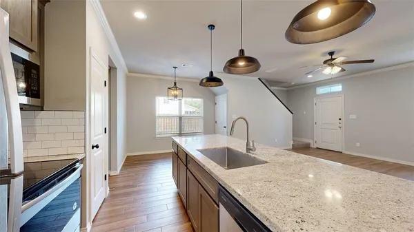 an open kitchen with a sink and chandelier