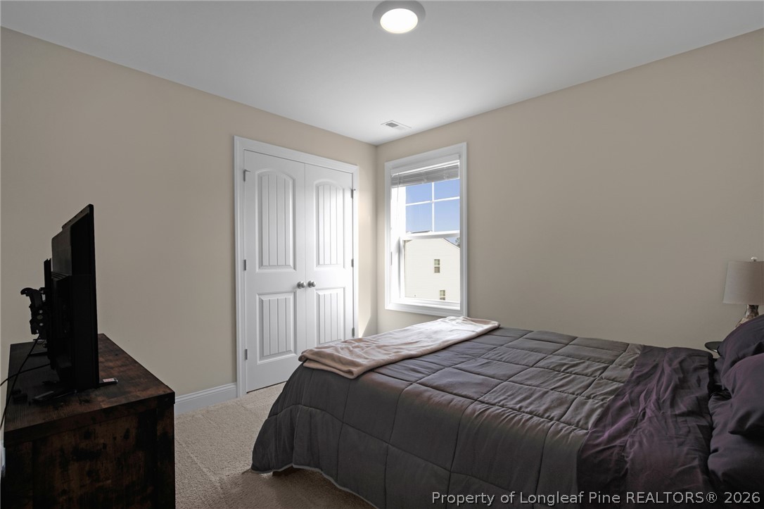 44 Princelet Point Cameron, NC 28326 - Photo 14 of 42 a bedroom with a bed and a flat tv screen on a dresser
