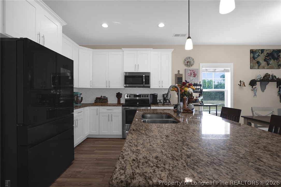 44 Princelet Point Cameron, NC 28326 - Photo 4 of 42 a living room with stainless steel appliances furniture a fireplace a flat screen tv and a kitchen view