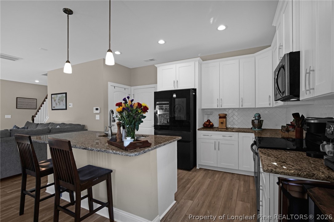 44 Princelet Point Cameron, NC 28326 - Photo 10 of 42 a kitchen with kitchen island granite countertop a sink a counter space appliances and cabinets