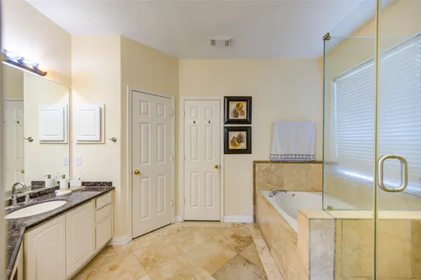 a bathroom with a tub sink and mirror