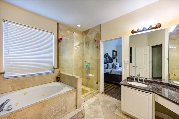 a spacious bathroom with a tub sink and mirror