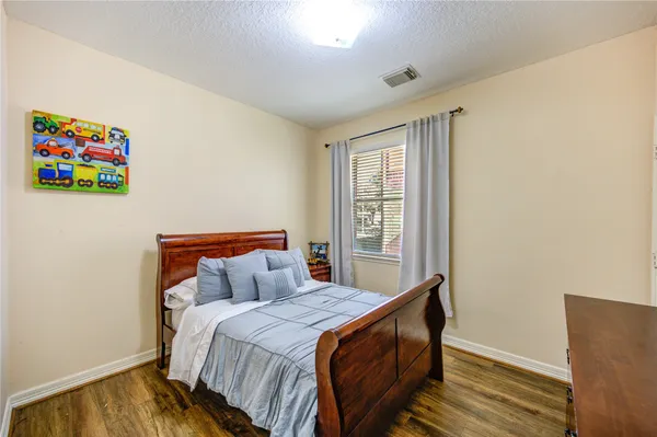 a bedroom with a bed and wooden floor
