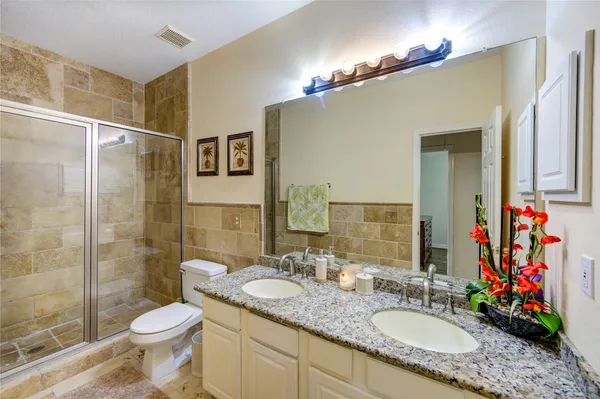 a bathroom with a granite countertop sink toilet and shower