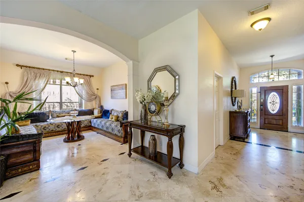 a living room with furniture a window and a chandelier