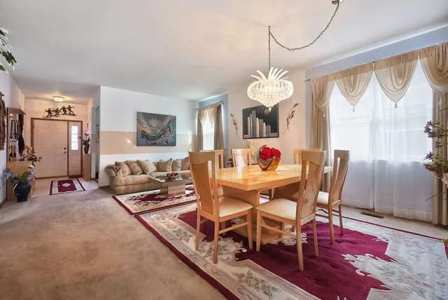 a view of a dining room with furniture a chandelier and wooden floor