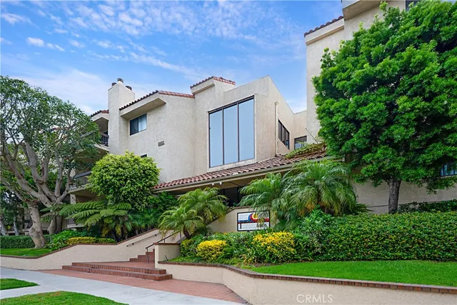 a front view of a house with a garden and plants