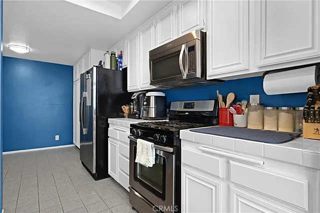 a kitchen with stainless steel appliances granite countertop a refrigerator and a stove top oven