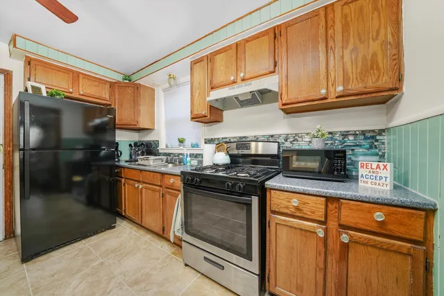 a kitchen with stainless steel appliances granite countertop a stove a sink and a refrigerator