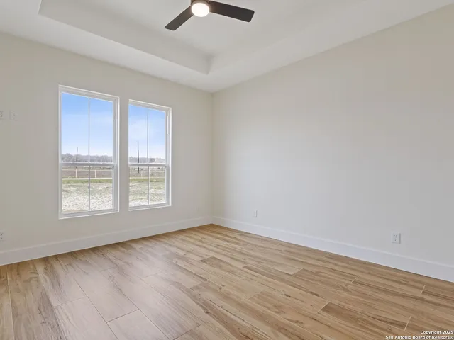 a view of an empty room with wooden floor