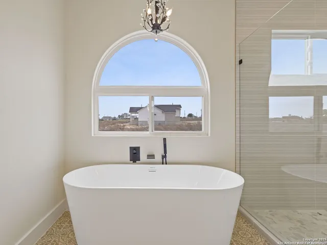 a bathroom with a tub a sink and mirror