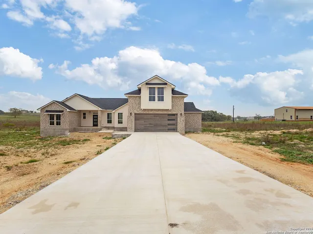 a view of a yard in front of a house with a large tree