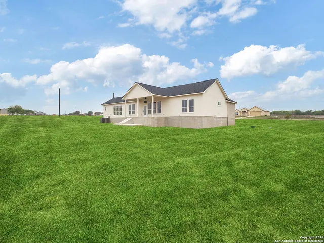 a view of a house with a garden and mountains