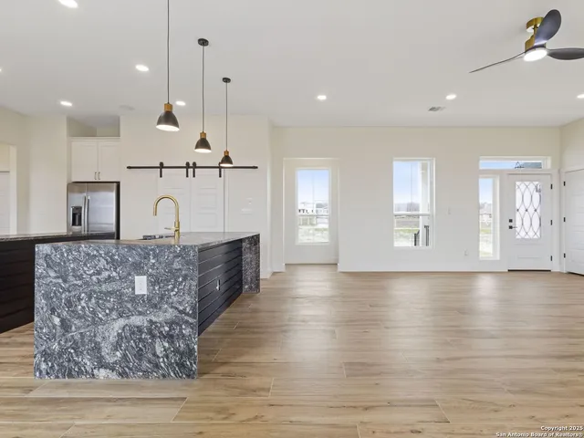 a open kitchen with kitchen island a counter top space a sink stainless steel appliances and cabinets