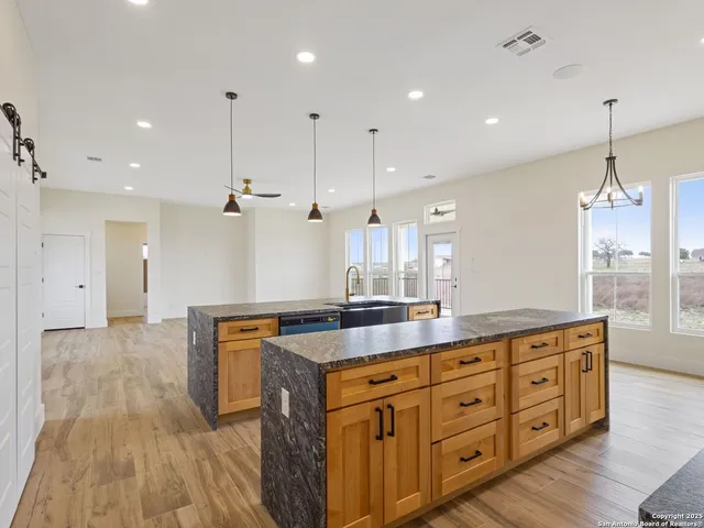 a large kitchen with kitchen island granite countertop a large counter top stainless steel appliances and cabinets