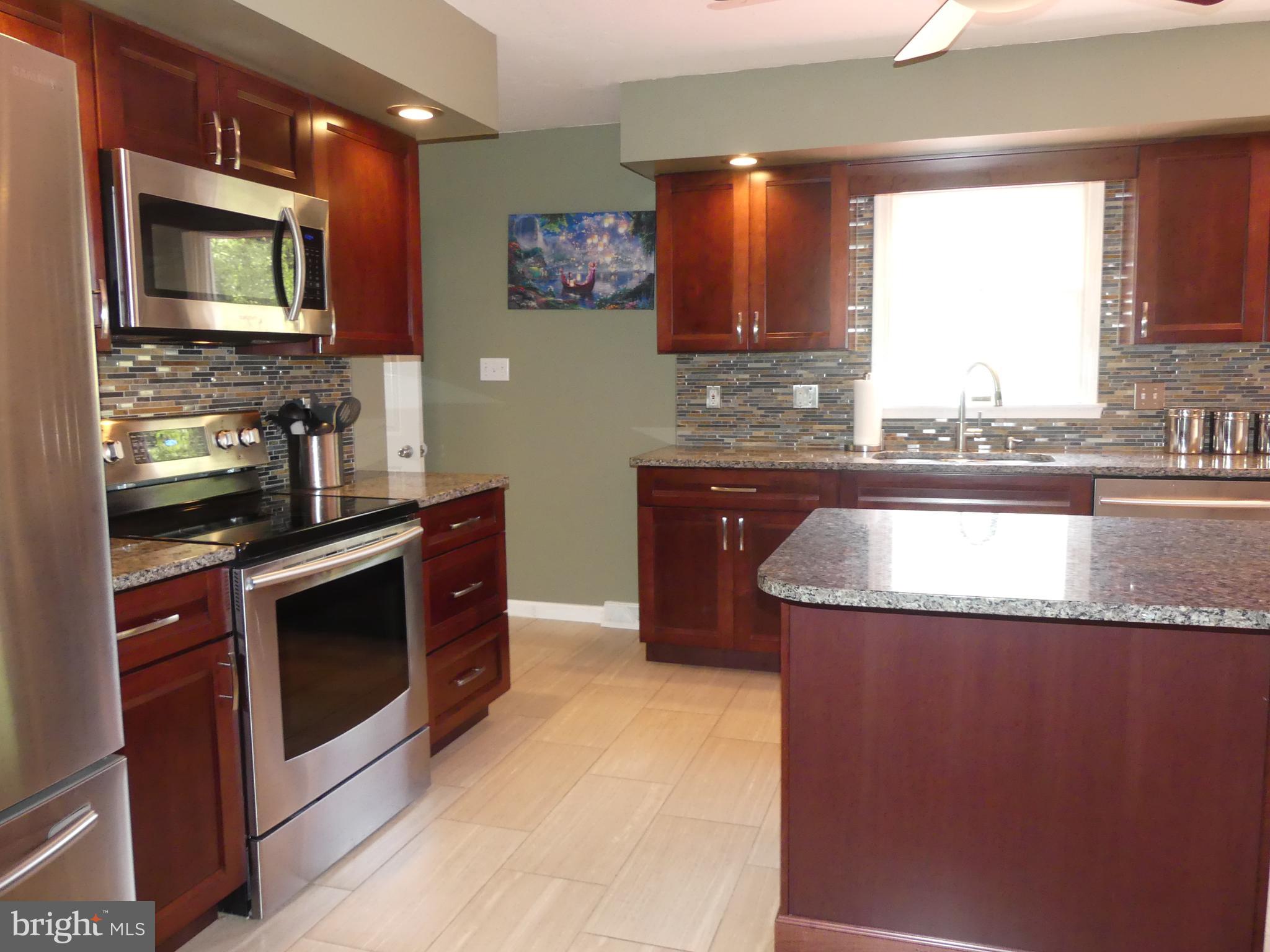 212 Ridley Drive York, PA 17402 - Photo 35 of 68 a kitchen with stainless steel appliances granite countertop a stove a sink and a microwave