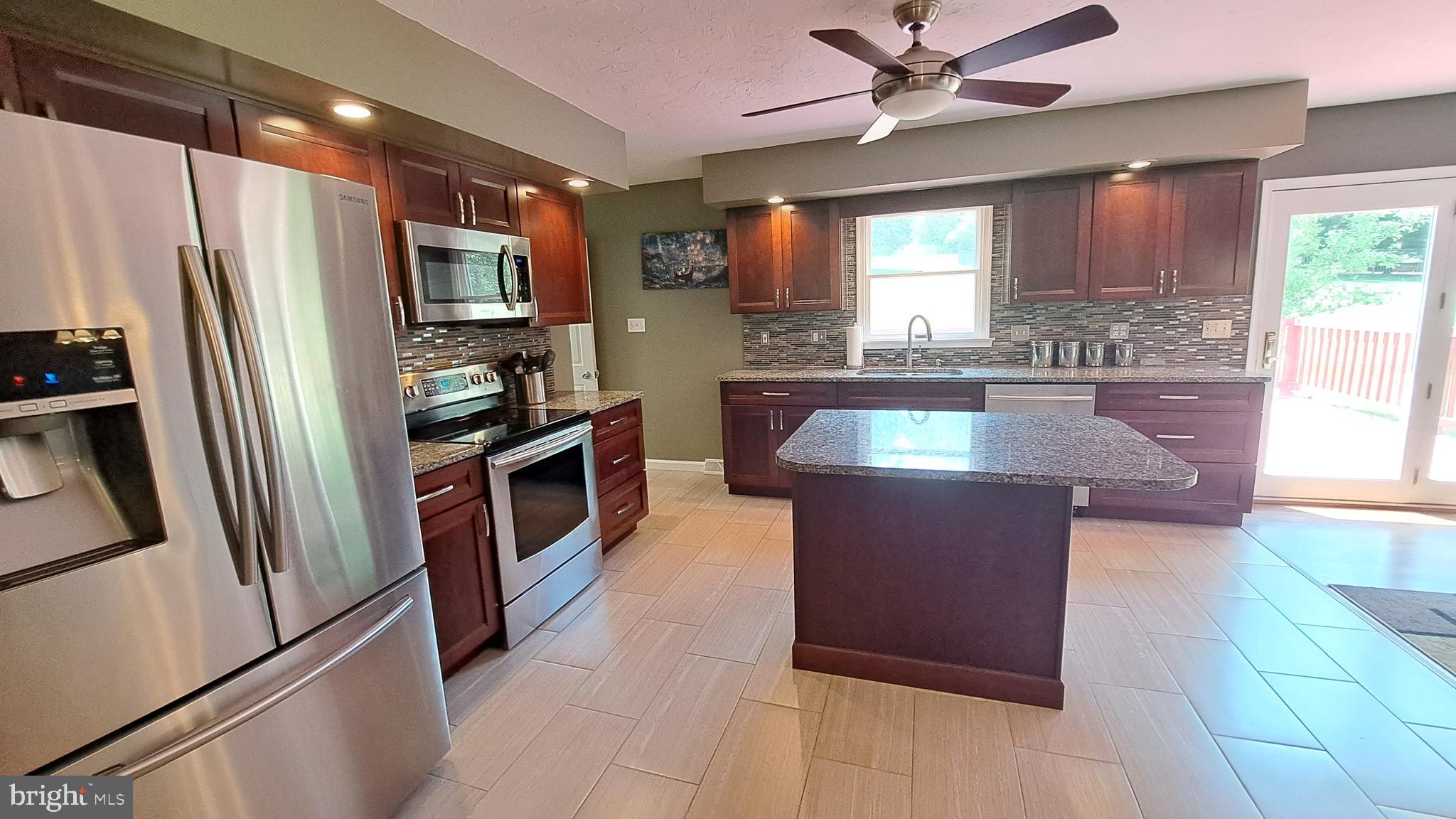 212 Ridley Drive York, PA 17402 - Photo 36 of 68 a kitchen with stainless steel appliances granite countertop a refrigerator a sink a stove a microwave and island