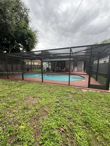 a front view of a house with a garden and trees