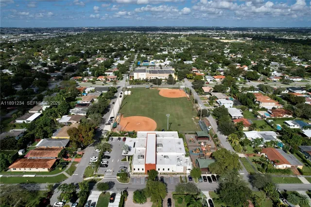 an aerial view of residential houses with outdoor space and trees