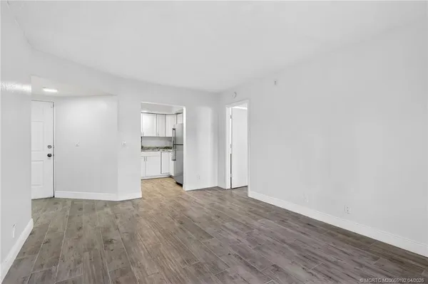a view of empty room with wooden floor