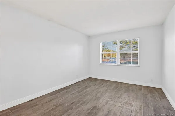 wooden floor in an empty room with a window