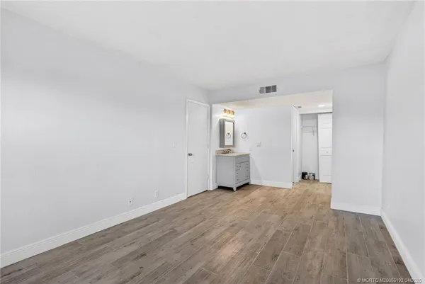a view of a room with wooden floor and white walls