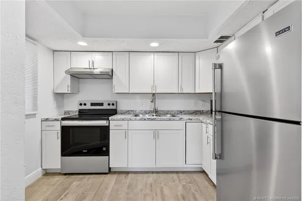 a kitchen with stainless steel appliances a refrigerator sink and stove