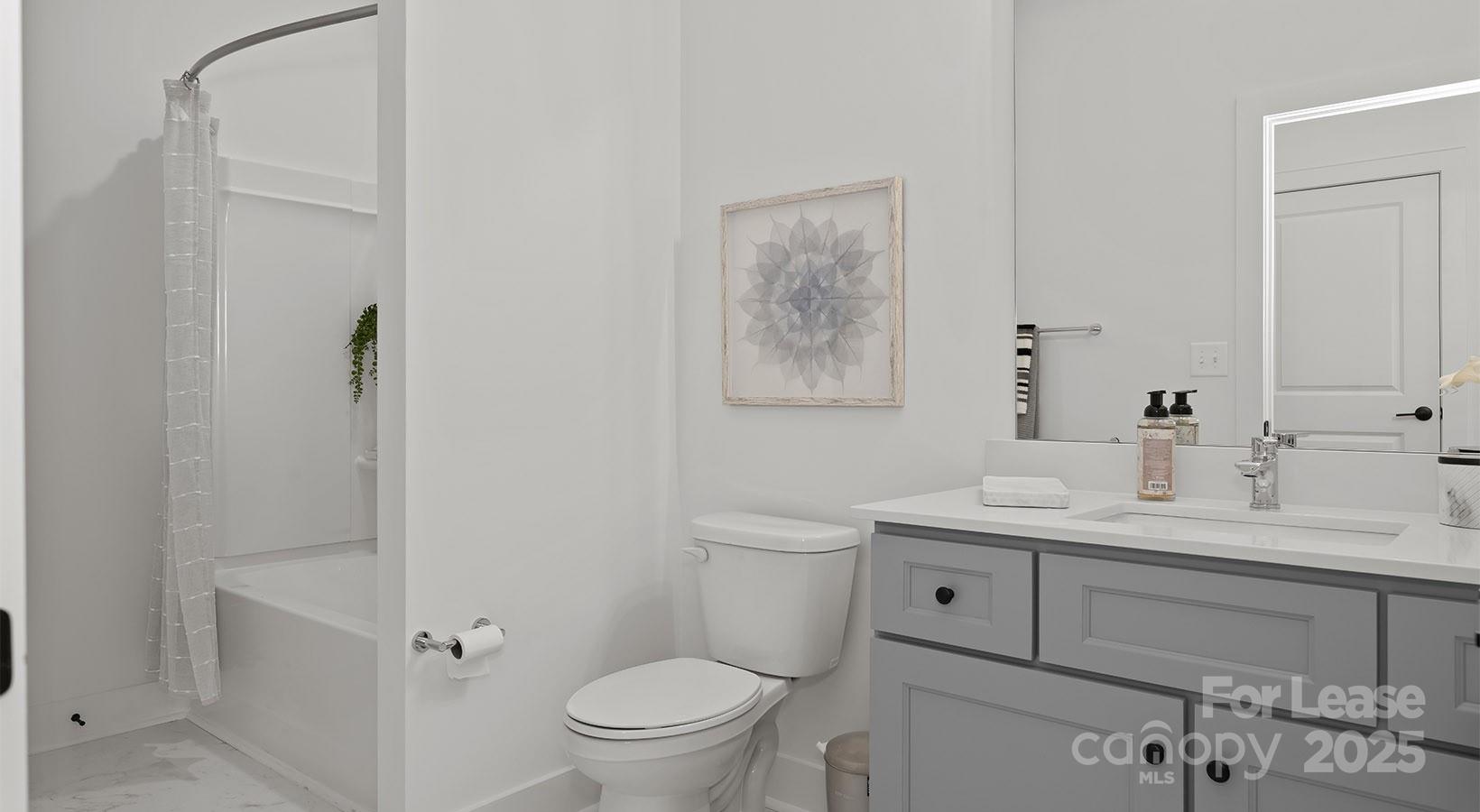 5150 Old Ridge Road, Unit B2 Charlotte, NC 28269 - Photo 20 of 27 a bathroom with a toilet a sink a mirror a vanity and shower