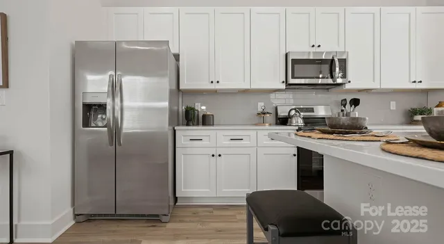 a kitchen with stainless steel appliances a refrigerator sink and cabinets