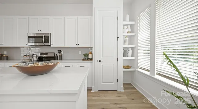 a kitchen with stainless steel appliances a refrigerator sink and white cabinets
