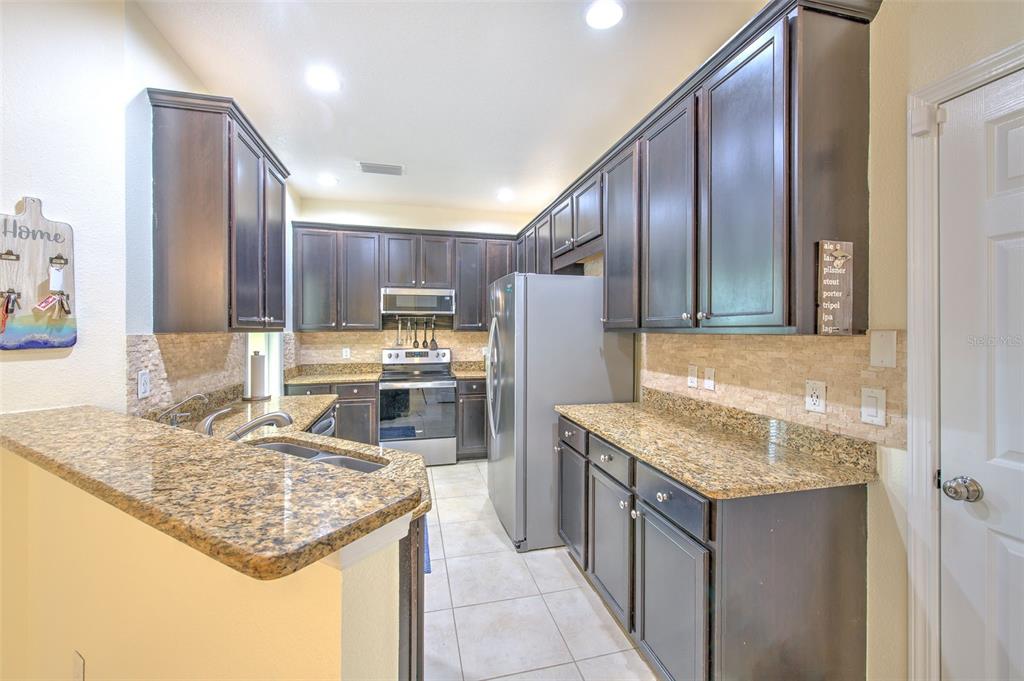 5409 Conch Shell Place Apollo Beach, FL 33572 - Photo 14 of 51 a kitchen with stainless steel appliances granite countertop a sink stove and refrigerator