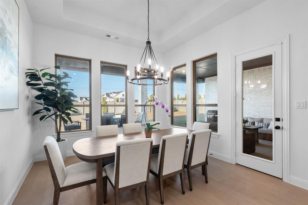 2248 Meander Way Northlake, TX 76247 - Photo 13 of 40 a dining room with furniture a chandelier and wooden floor