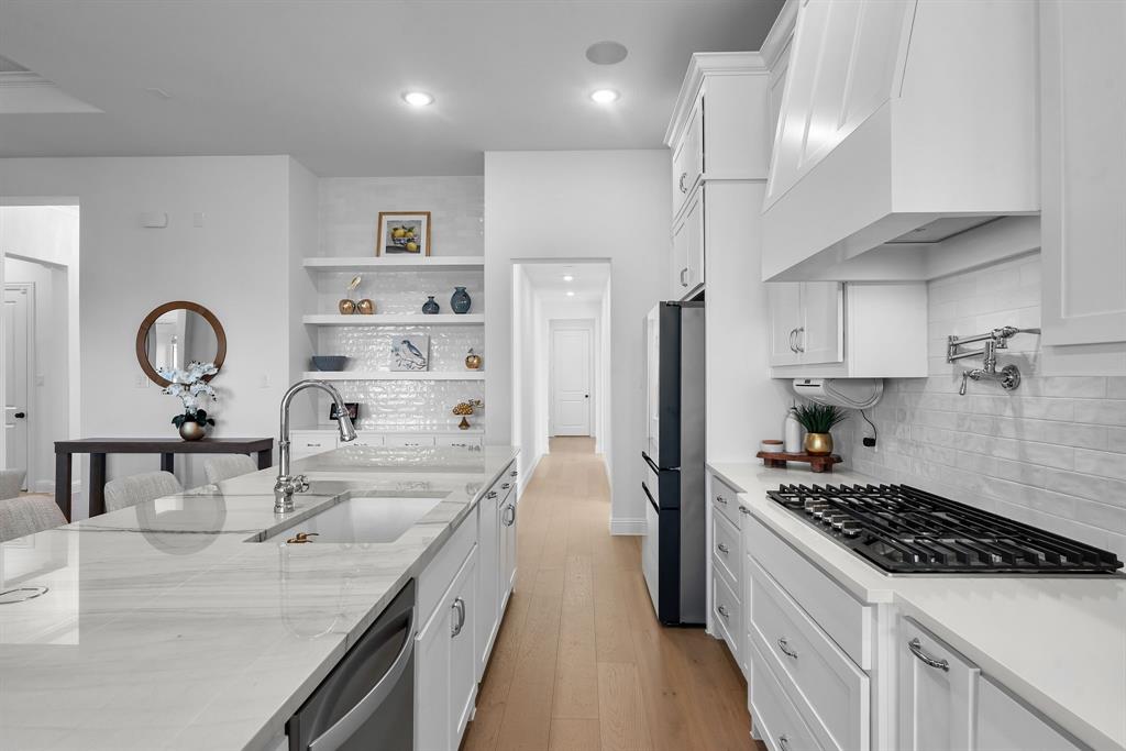 2248 Meander Way Northlake, TX 76247 - Photo 15 of 40 a kitchen with kitchen island a counter space a sink a stove and refrigerator