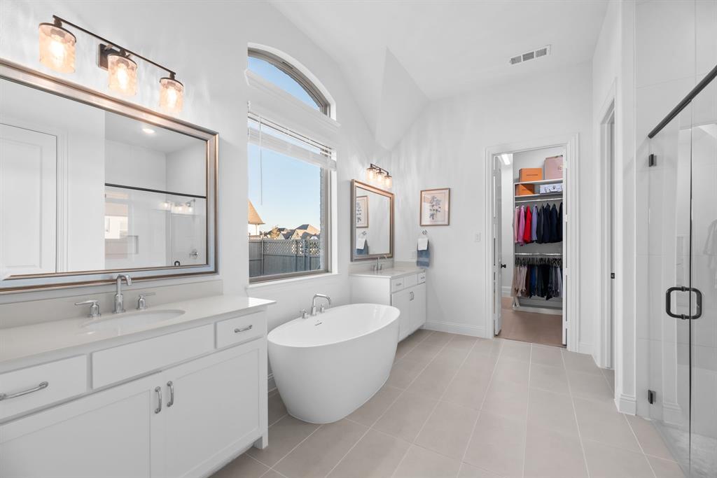 2248 Meander Way Northlake, TX 76247 - Photo 20 of 40 a bathroom with a double vanity sink a large mirror and a bathtub